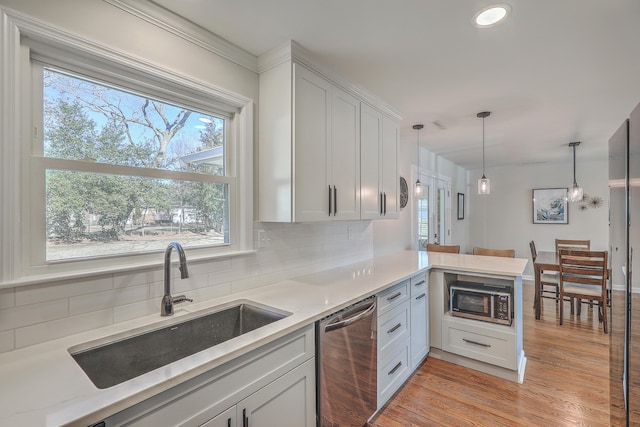 kitchen with stainless steel dishwasher, kitchen peninsula, built in microwave, and hanging light fixtures