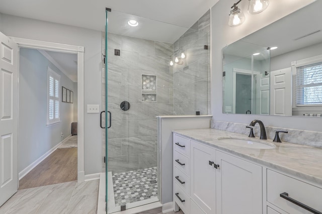 bathroom featuring vanity and a shower with shower door