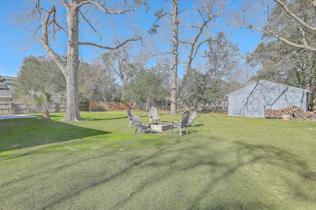 view of yard featuring an outdoor fire pit and an outdoor structure