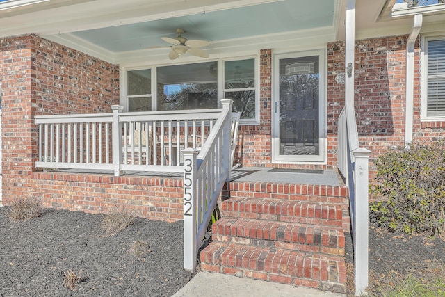 view of exterior entry with ceiling fan and covered porch