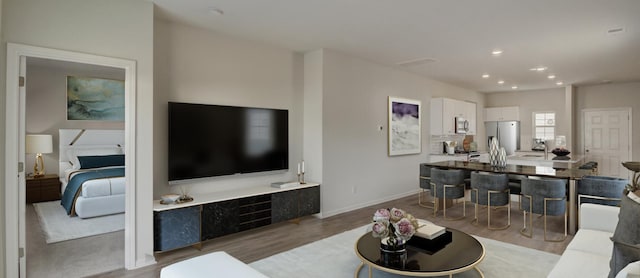 living area featuring baseboards, wood finished floors, and recessed lighting