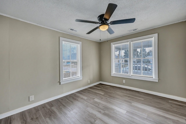 unfurnished room featuring ornamental molding, a textured ceiling, and light wood-type flooring