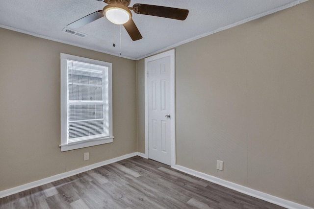 unfurnished room with crown molding, ceiling fan, and light wood-type flooring