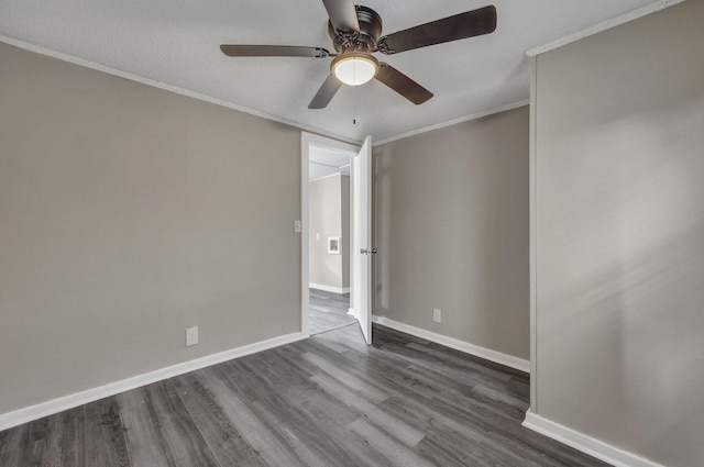 empty room featuring crown molding, dark wood-type flooring, and ceiling fan