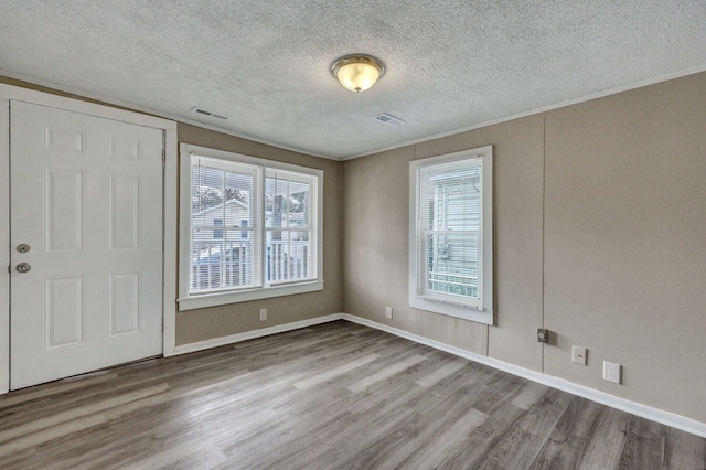 foyer entrance with a healthy amount of sunlight, wood-type flooring, and a textured ceiling