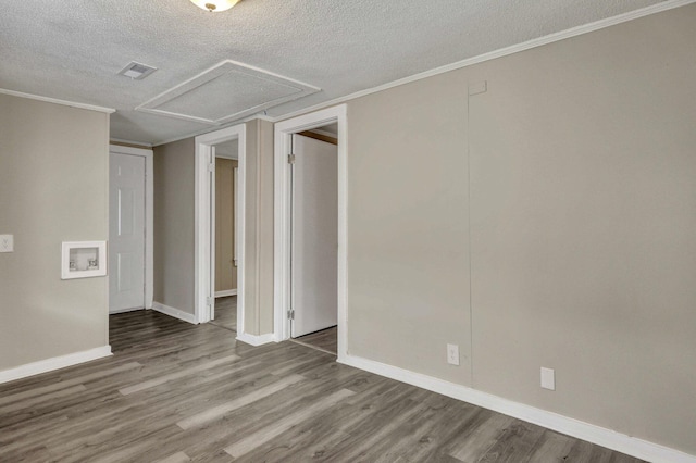 empty room featuring hardwood / wood-style floors, ornamental molding, and a textured ceiling