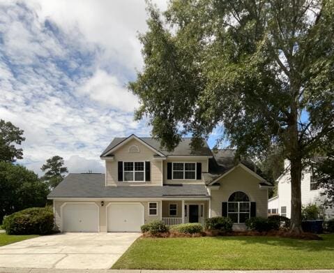 view of front of home with a front yard and a garage