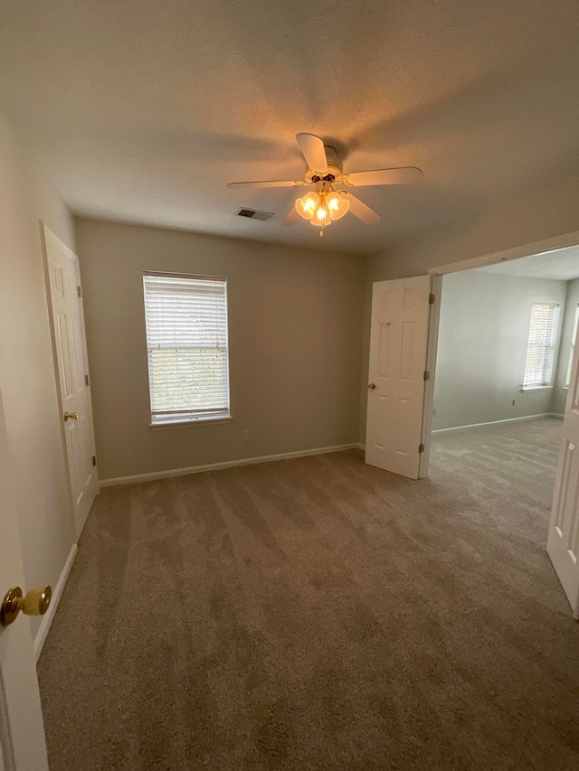 unfurnished bedroom with carpet floors, a textured ceiling, and ceiling fan