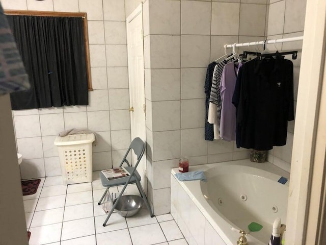 bathroom with tile patterned flooring, tile walls, and tiled tub