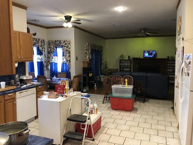 kitchen featuring white appliances, ornamental molding, a center island, and ceiling fan