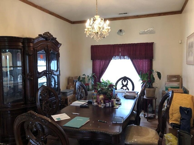 dining area featuring crown molding, wood-type flooring, and a chandelier