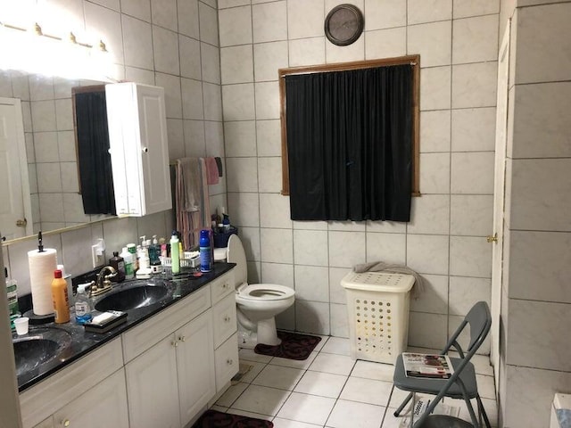 bathroom with tile patterned floors, toilet, vanity, and tile walls