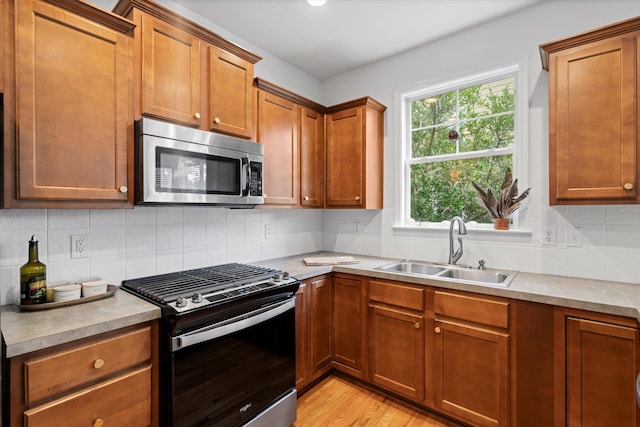 3000 Treadwell St, Mount Pleasant, SC 29466 - kitchen featuring appliances with stainless steel finishes, a sink, light countertops, light wood-type flooring, and backsplash