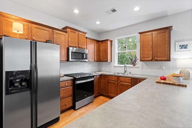 3000 Treadwell St, Mount Pleasant, SC 29466 - kitchen with stainless steel appliances, a sink, light wood finished floors, brown cabinets, and recessed lighting