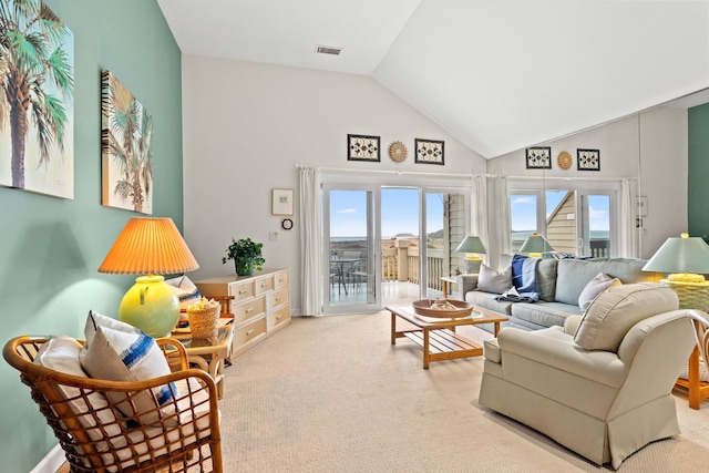 carpeted living room with visible vents and high vaulted ceiling