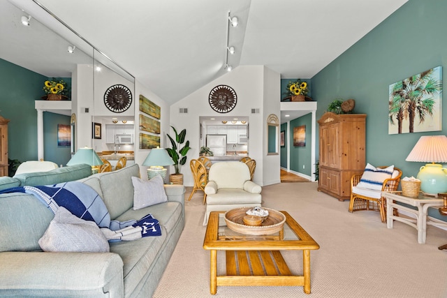 carpeted living area featuring track lighting, baseboards, visible vents, and high vaulted ceiling