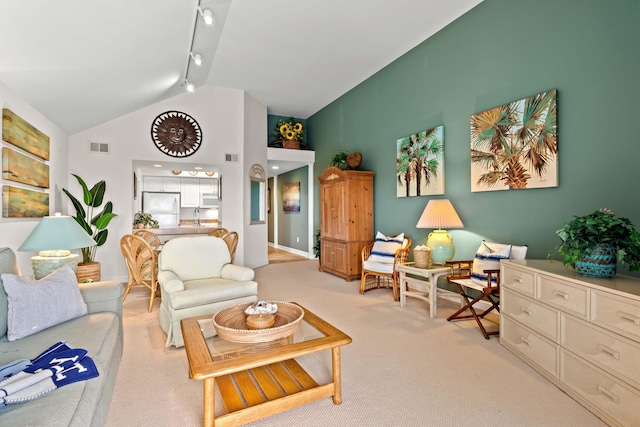 carpeted living area with a sink, visible vents, high vaulted ceiling, and track lighting