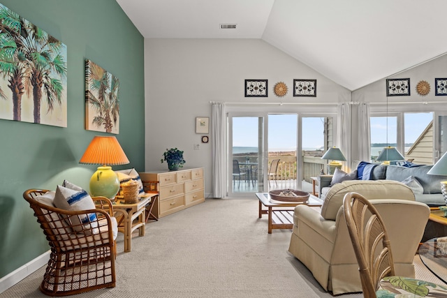 carpeted living area with baseboards, visible vents, and high vaulted ceiling