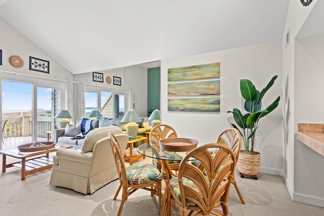 dining area featuring visible vents, baseboards, light colored carpet, and vaulted ceiling