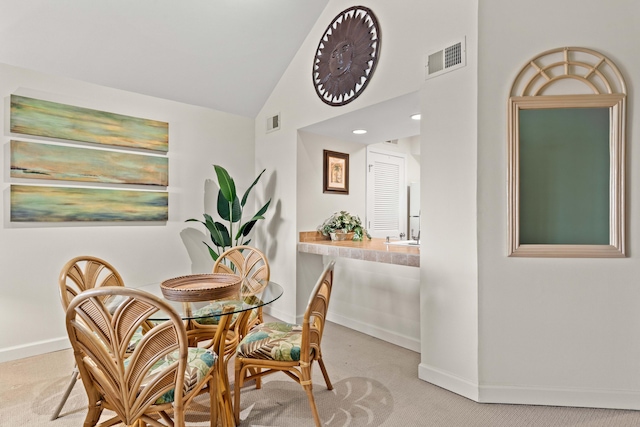 dining room with visible vents, baseboards, carpet, and vaulted ceiling