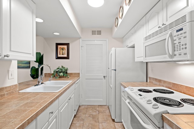 kitchen with visible vents, recessed lighting, white cabinets, white appliances, and a sink