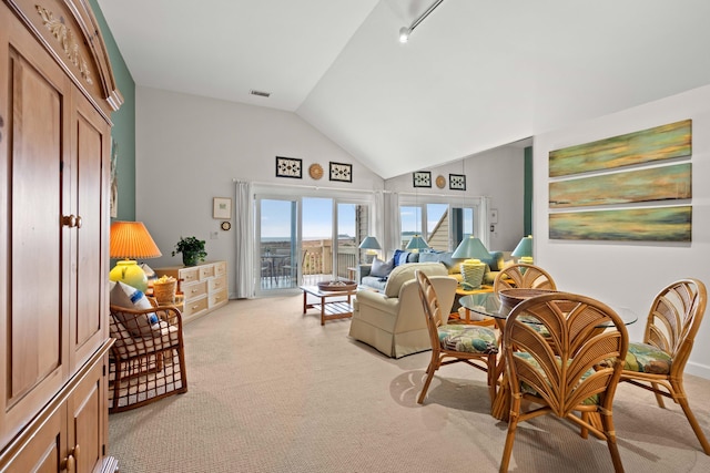 living room featuring high vaulted ceiling, visible vents, and light carpet