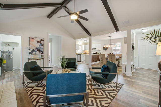 living area featuring light wood-style floors, beam ceiling, electric water heater, and visible vents