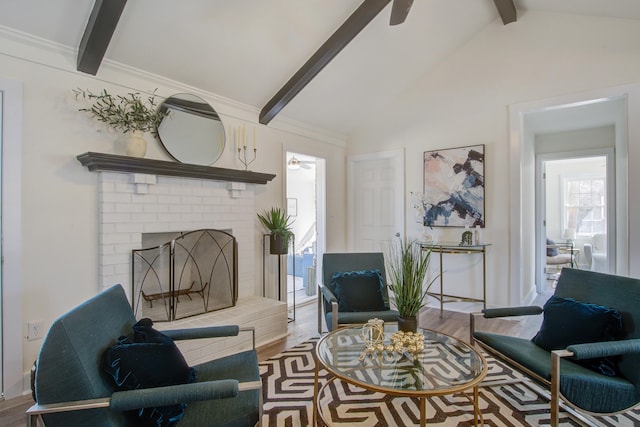 living area with ceiling fan, a fireplace, vaulted ceiling with beams, and wood finished floors