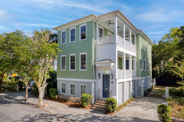 view of front of property with a garage, a balcony, and ceiling fan