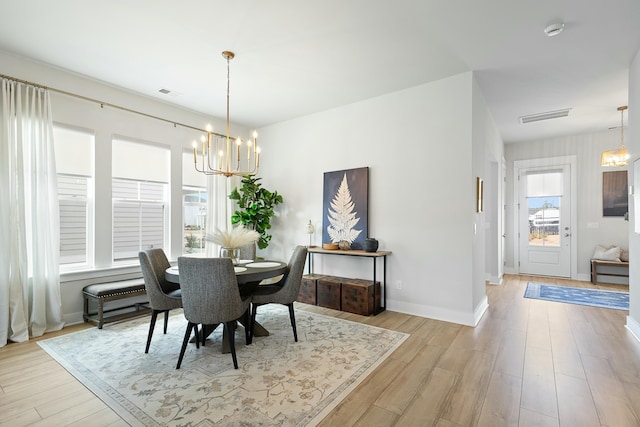 dining space featuring light wood-type flooring and a chandelier