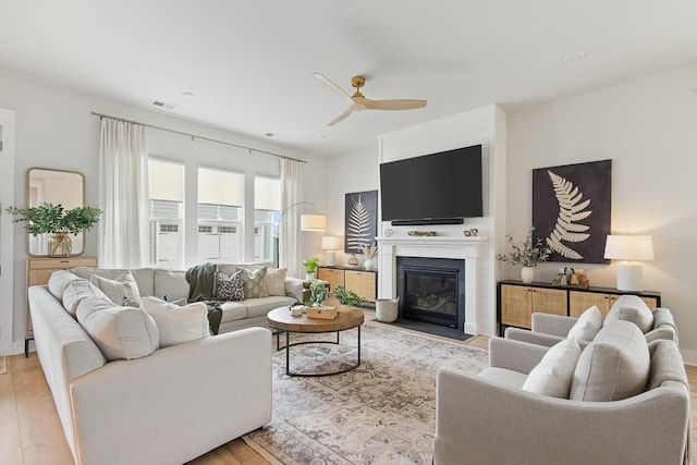 living room featuring ceiling fan and light hardwood / wood-style floors