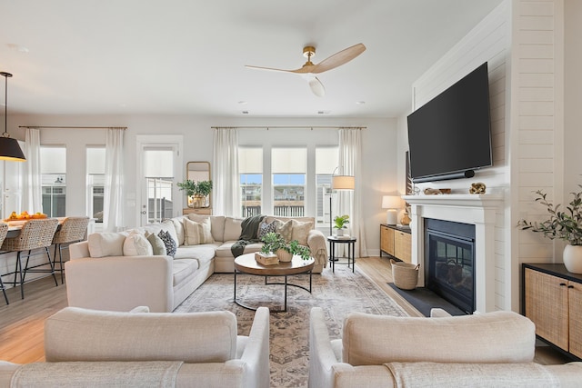 living room with ceiling fan and light hardwood / wood-style flooring