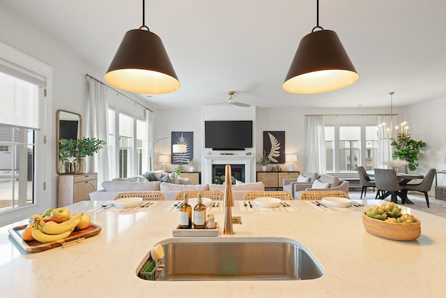 kitchen featuring hanging light fixtures, light stone countertops, and a healthy amount of sunlight