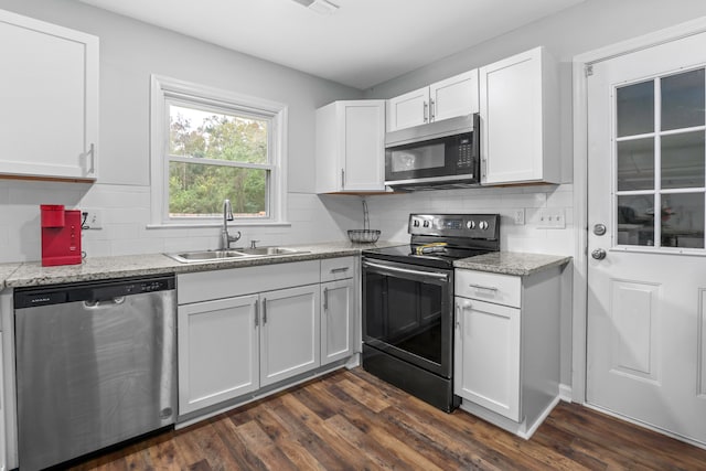 kitchen featuring sink, dark hardwood / wood-style floors, light stone counters, white cabinetry, and stainless steel appliances