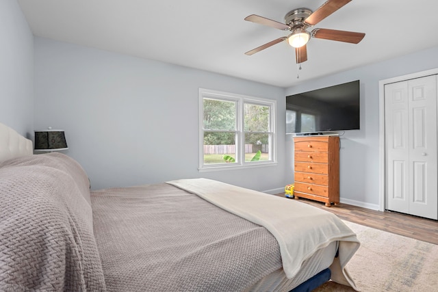 bedroom with hardwood / wood-style flooring, ceiling fan, and a closet