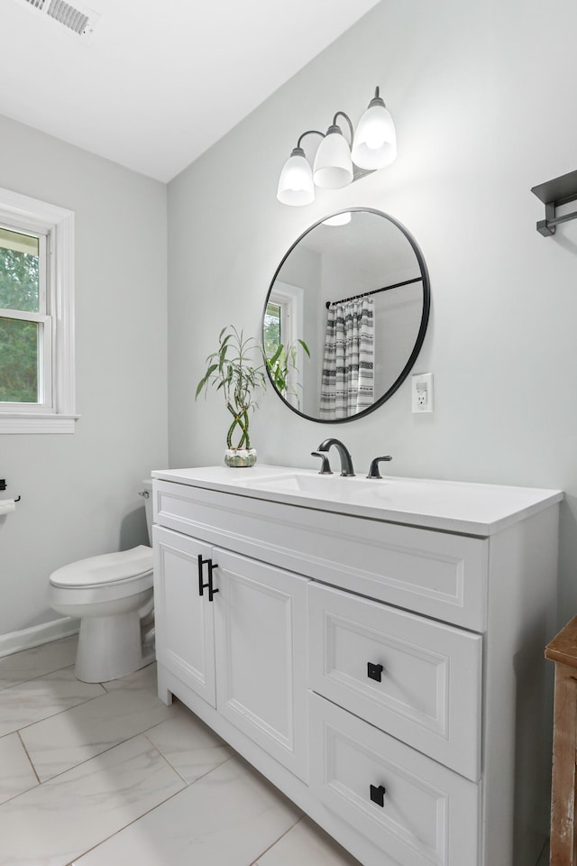 bathroom featuring vanity, toilet, and walk in shower