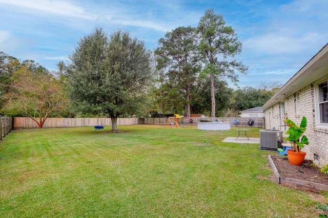 view of yard featuring cooling unit and a pool