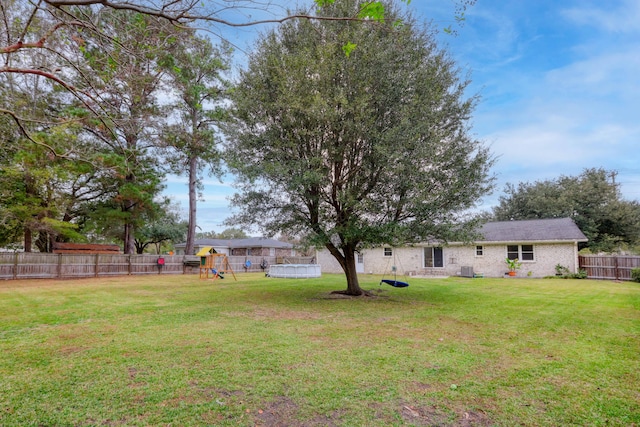 view of yard with a pool and a playground