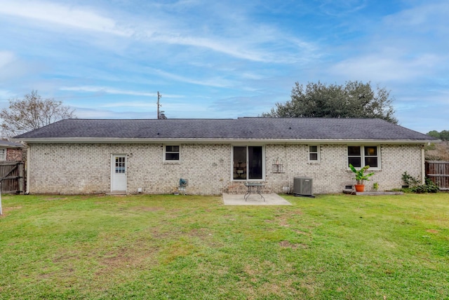 back of property with central AC unit, a patio, and a lawn