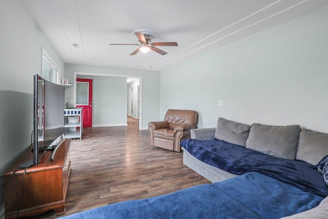 living room with dark hardwood / wood-style flooring and ceiling fan