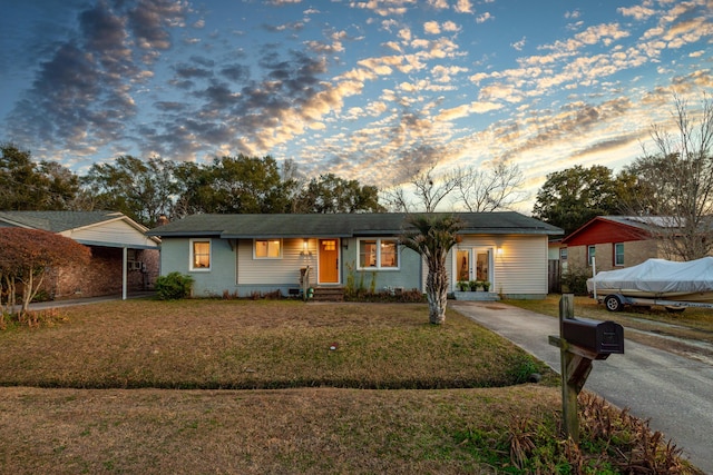 single story home with a yard and a carport