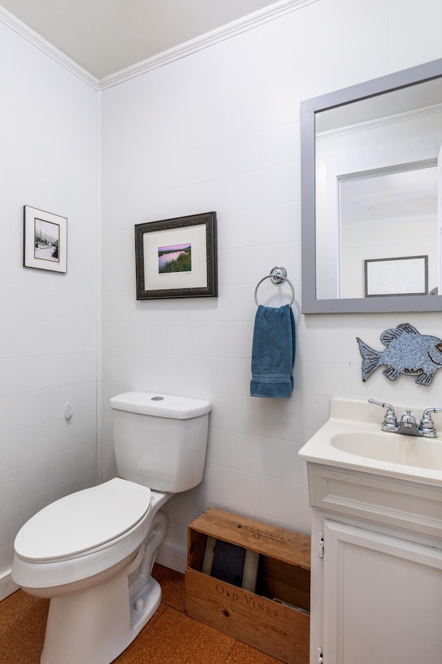 bathroom featuring toilet, vanity, and ornamental molding