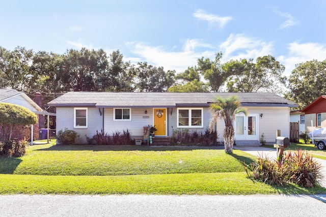 ranch-style home with french doors and a front lawn