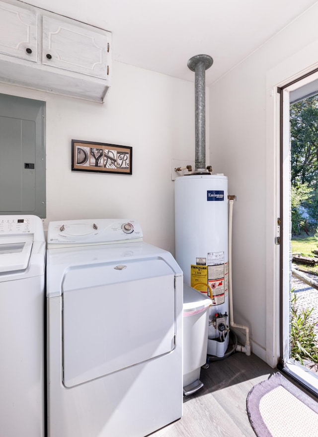 laundry room with electric panel, cabinets, hardwood / wood-style flooring, gas water heater, and washing machine and dryer