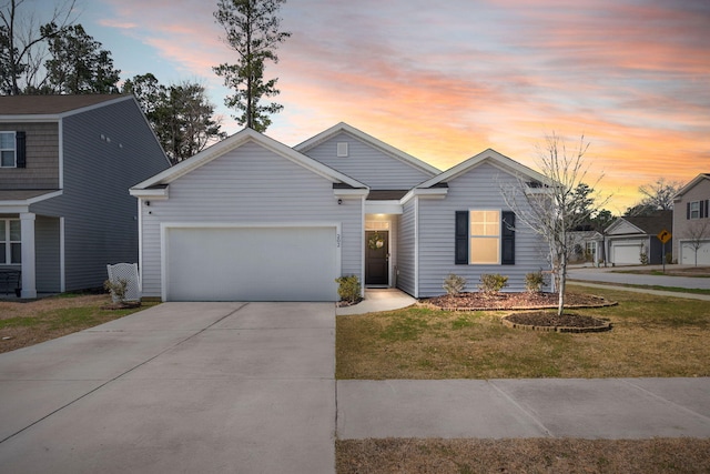 view of front facade with an attached garage, a lawn, and concrete driveway