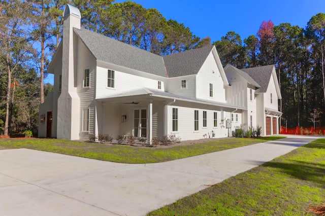 view of side of home with a lawn, ceiling fan, and a garage