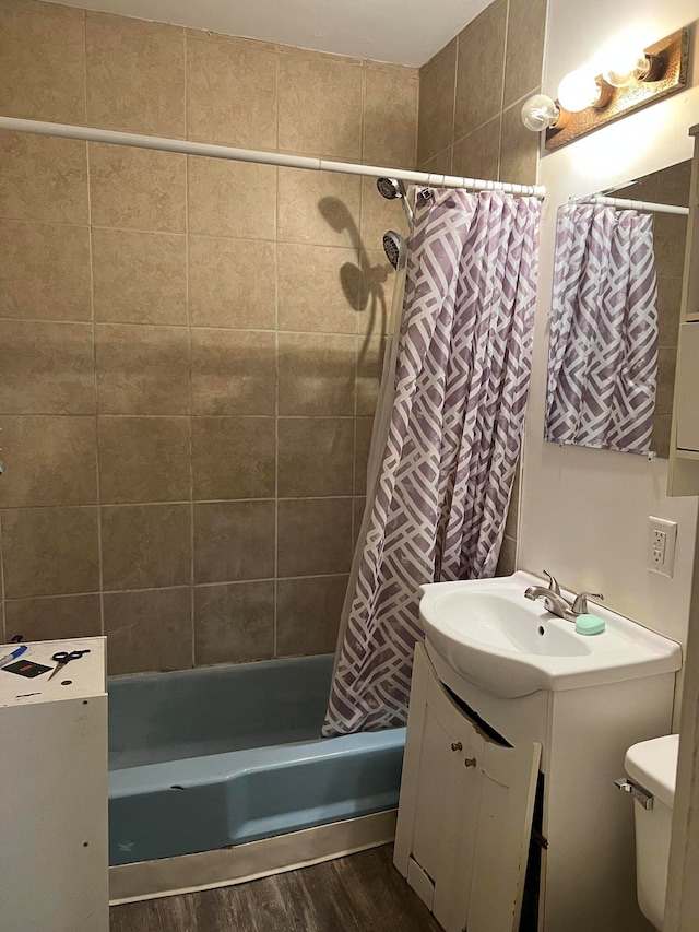 full bathroom featuring toilet, shower / bath combination with curtain, hardwood / wood-style flooring, and vanity