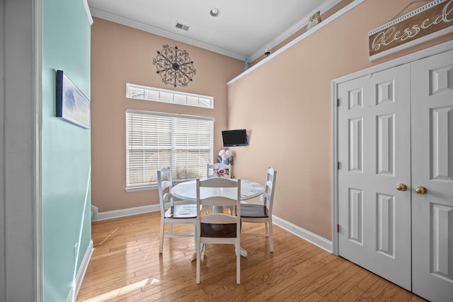 dining space featuring visible vents, baseboards, ornamental molding, and light wood finished floors