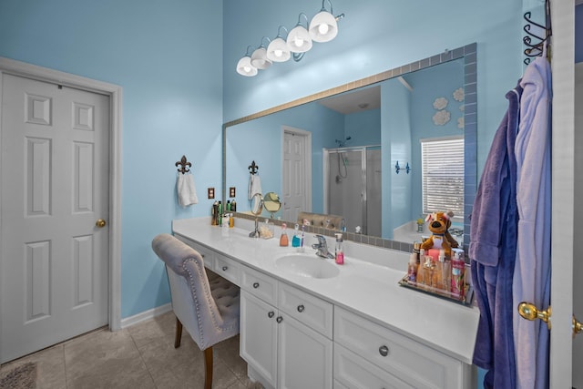 bathroom featuring vanity, tile patterned floors, baseboards, and a stall shower