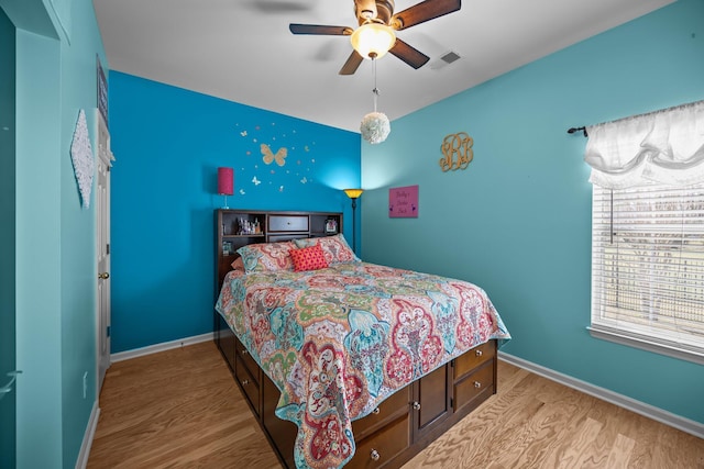 bedroom featuring ceiling fan, baseboards, and wood finished floors